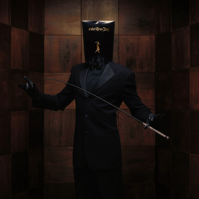 photo by Erwin Olaf of well dressed man wearing a glossy black YSL back on head